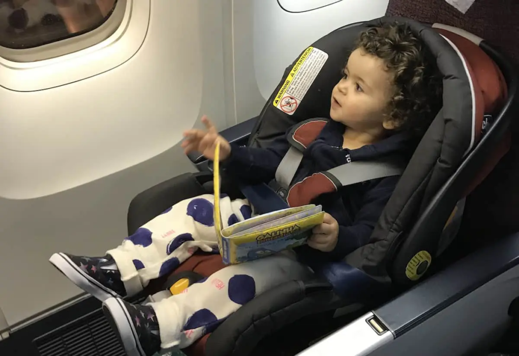 bebê sentado na cadeirinha em um assento de avião